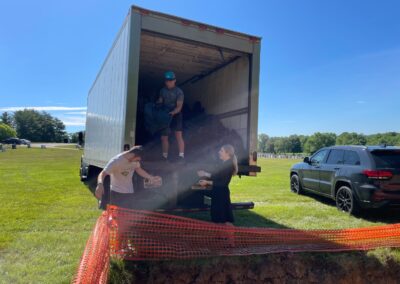 Teenagers unloading a truck of objects for a shaimos burial